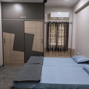 钦奈Sukrithi Premium Serviced Apartment - F2的一间卧室设有两张床,其中设有窗户。