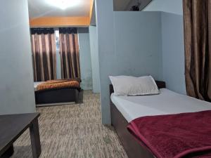 甘托克Lama Hotel的一间小房间,配有两张床和一张沙发