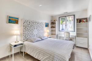 帕拉瓦莱弗洛Les Palmiers的白色的卧室设有床和窗户
