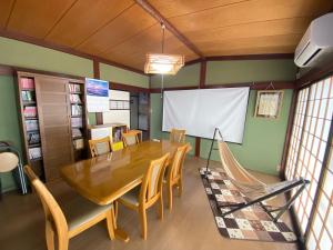富山ゲストハウス山吹的一间带木桌和椅子的用餐室