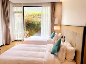 张家界XMAN Valley Sunrise Resort的酒店客房,设有两张床和一张沙发