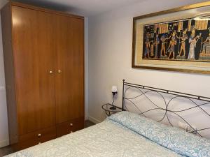 Sant Joan de VilatorradaApartament Sant Jordi的卧室配有一张床,墙上挂有绘画作品