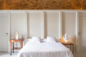 马泰拉Masseria Fontana di Vite的卧室配有白色的床和砖墙