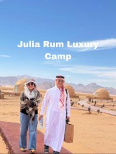 瓦迪拉姆Julia Rum Luxury Camp的走在沙漠中的男人和女人