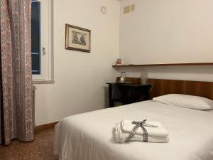 拉齐塞Albergo da Pina的酒店客房,配有一张带弓的床铺