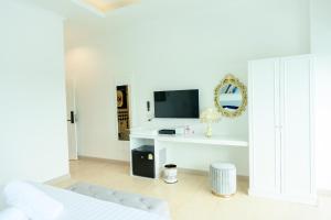 黎府Marble Arch De Loei Hotel的一间白色卧室,配有床和电视