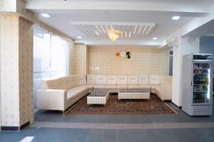 班加罗尔Treebo Trend Galaxy Kings Suites - Hebbal的客厅配有白色沙发和冰箱。
