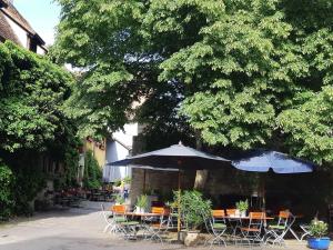 罗滕堡艾尔弗拉恩基斯克葡萄酒馆酒店的一个带桌椅和遮阳伞的庭院。