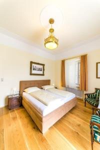 巴特格莱兴贝格Villa Thalhof的一间卧室配有一张大床和一个吊灯。