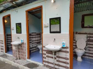 吉布Himtrek Camps Jibhi的浴室设有两个卫生间,墙上设有两个水槽。