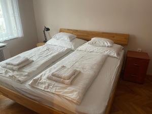 MarcaliPlatán Apartman的卧室内的两张床,配有白色的床单和毛巾