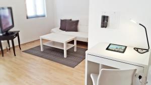 艾森纳赫Alte Uhrmacherei Eisenach的客厅配有白色桌子和白色沙发