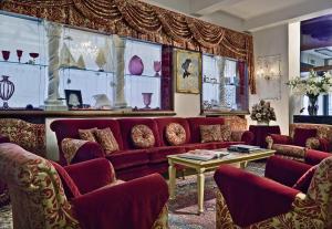 威尼斯乔尔乔涅酒店的客厅配有红色的沙发和桌子