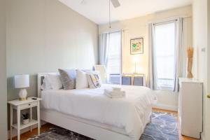 华盛顿Classy 1-BR Flat Nestled Between Dupont & Logan的白色的卧室设有白色的床和窗户。