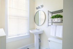 华盛顿Classy 1-BR Flat Nestled Between Dupont & Logan的白色的浴室设有水槽和镜子