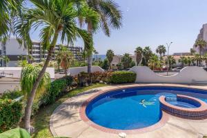 卡波圣卢卡斯Villa Calafia Spacious Home w Private Tennis的度假村内棕榈树游泳池