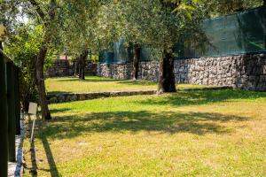 托斯科拉诺-马德尔诺Camping Toscolano的一座有树木和石墙的公园