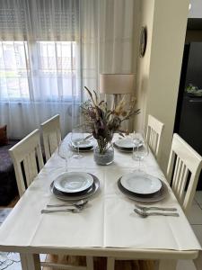 斯库台Sol Apartments - 2 Bedrooms的一张带盘子和酒杯的白色桌子