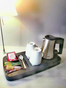 宾茨尼福桑巴酒店公寓的一个带咖啡壶和纸质毛巾的托盘