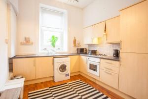 格拉斯哥Stunning 2 bed property in heart of West End的厨房配有洗衣机和窗户。