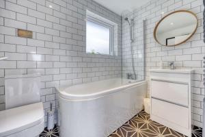 HayfieldNew Build Lodge With Stunning Views of Loch Awe的白色的浴室设有浴缸、水槽和镜子