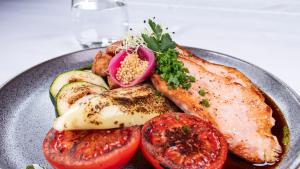 索普隆玫瑰园酒店&餐厅的桌上一盘带肉和蔬菜的食物