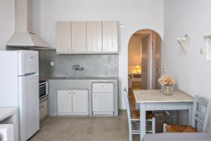 提诺斯Artemis Apartments的厨房配有桌子和白色冰箱。