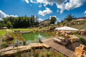 鲁哈科维斯奥古斯汀尼斯基康体和温泉酒店的一个带庭院和遮阳伞的游泳池