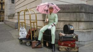 曼彻斯特哥谭酒店的把粉红色伞放在行李上的女人