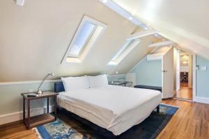 基韦斯特Sky Loft in Key West by Brightwild的一间卧室配有一张床和两个天窗