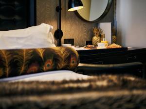 曼彻斯特哥谭酒店的一间卧室配有一张床和一张带镜子的书桌