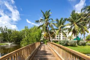 基韦斯特The Samana Cay by Brightwild-Private Balcony的一座棕榈树和建筑的河流上的桥梁