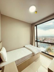 巴淡岛中心Vanilla One Residence Apartment Batam的一间卧室设有一张床和一个大窗户