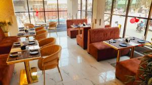 SiwānHotel Grand Patliputra的餐厅设有桌椅和窗户。