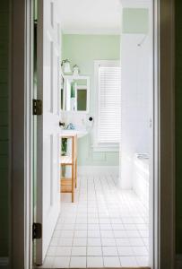 基韦斯特King Suite Balcony by Brightwild- at James House的一间带水槽的浴室和白色瓷砖地板。