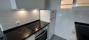 圣埃乌拉利亚Siesta Mar Apartamentos Ibiza的白色的厨房配有冰箱和窗户。