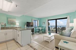 德通纳海滩海岸Aquamarine Suite at Sunglow Resort by Brightwild的厨房以及带沙发和桌子的客厅。