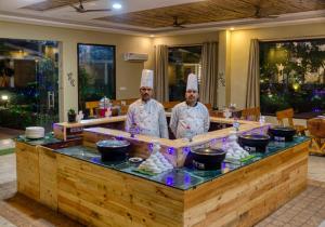 兰纳加De Floresta Resort的餐厅的柜台后面有两名厨师