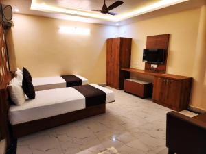 SiwānHotel Grand Patliputra的酒店客房设有两张床和电视。