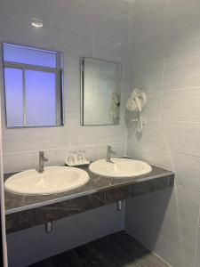 合艾合艾尼奥酒店的浴室设有2个水槽和镜子