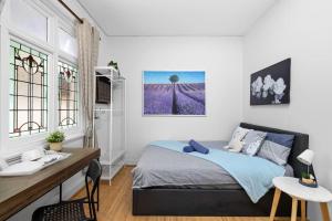 悉尼Lidcombe Boutique Guest House near Berala Station的卧室配有一张床、一张书桌和窗户。