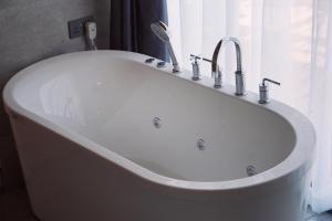 奈瓦沙THE ARK PARADIO LODGE的白色浴缸、水槽和窗户