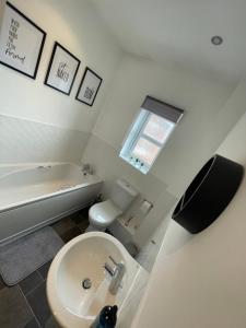 锡厄姆Seaham Sea View 2 bedroom apartment的浴室配有卫生间、盥洗盆和浴缸。
