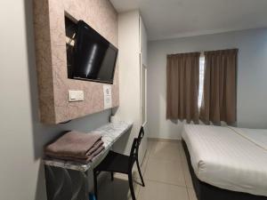 吉隆坡Mozu Hotel Sri Hartamas的客房设有一张床、一张书桌和电视
