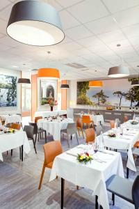 圣福瓦莱里昂圣约瑟夫里昂葡萄园酒店的一间设有白色桌子和橙色椅子的餐厅