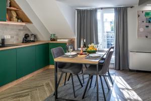 普罗夫迪夫8th Hill的厨房配有绿色橱柜和一张带椅子的木桌
