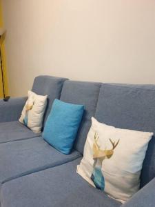 居林D' Permata Homestay Kulim的蓝色的沙发,上面有三个枕头,上面有鹿