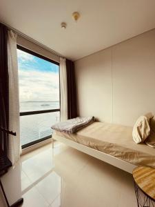 巴淡岛中心Vanilla One Residence Apartment Batam的一间卧室设有一张床和一个大窗户
