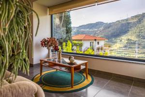 雷森迪Fraga Douro House, Douro Valley的客厅设有桌子和大窗户