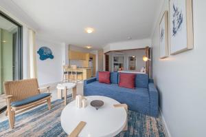 埃尔利海滩水边度假酒店的客厅配有蓝色的沙发和桌子